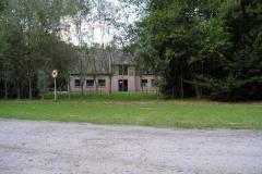 Vooraanzicht blokhut vanaf zandpad
